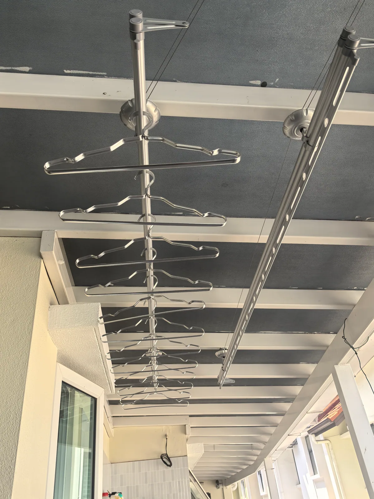 Electric clothes drying rack installed on an awning metal frame structure