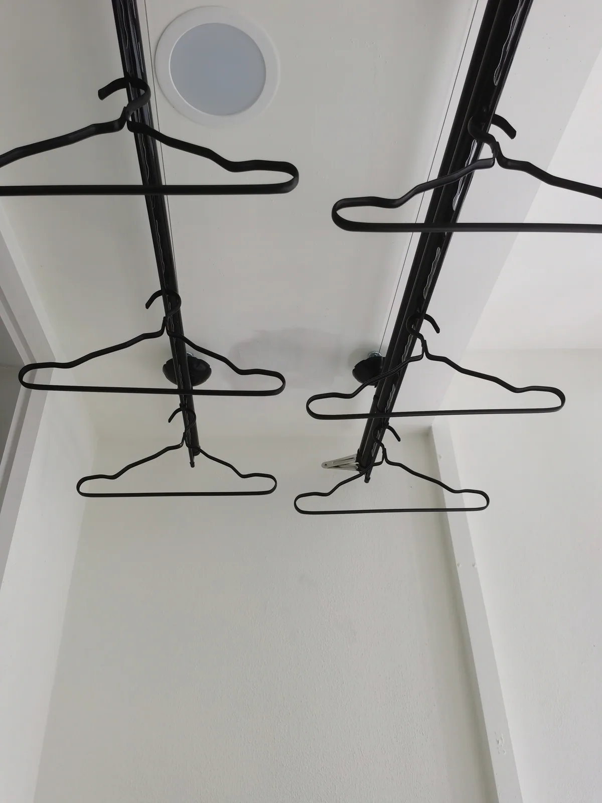 Close-up of a drying rack installed beneath a plaster ceiling